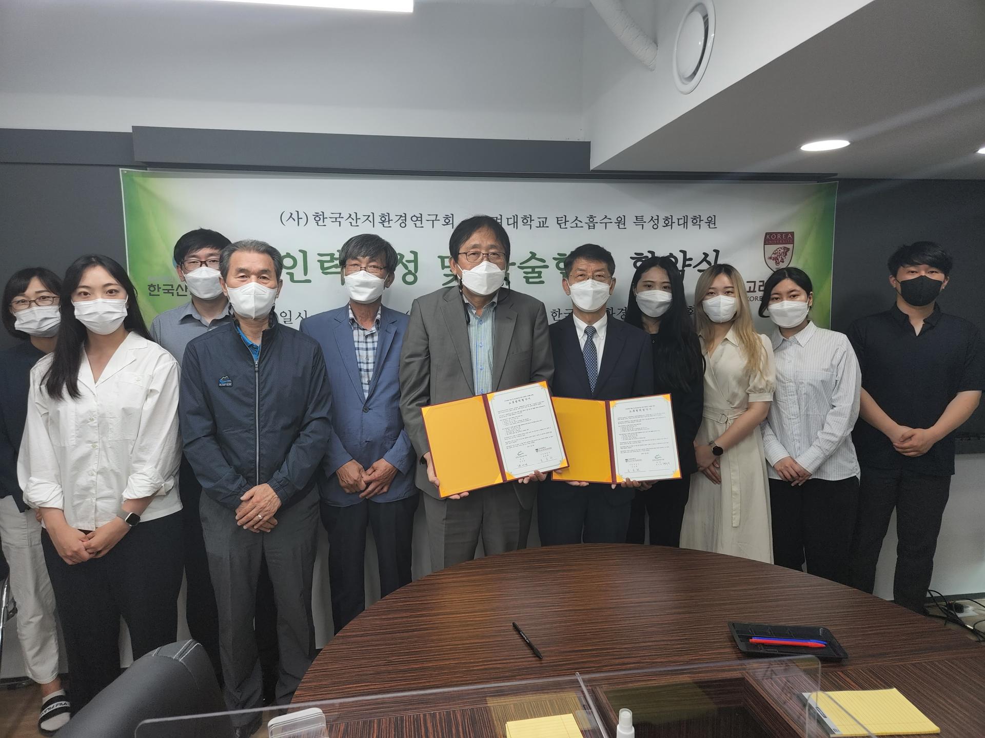 고려대학교 업무협약 체결 후 양측 참석자들이 협약서를 들고 단체로 기념하는 모습