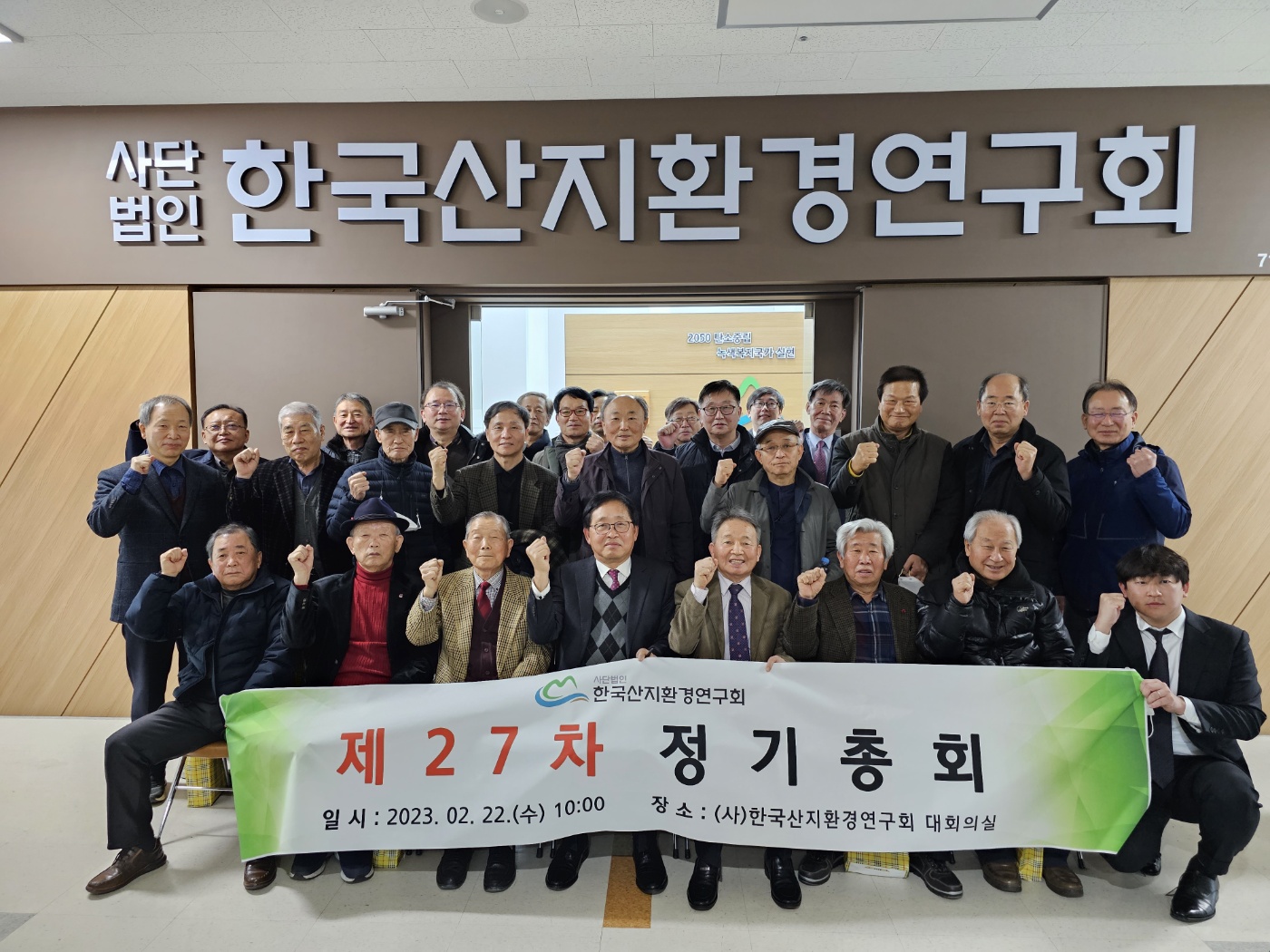 제27차 정기총회를 마친 회원들이 사단법인 한국산지환경연구회 현판 아래에서 현수막을 들고 단체로 기념하는 모습