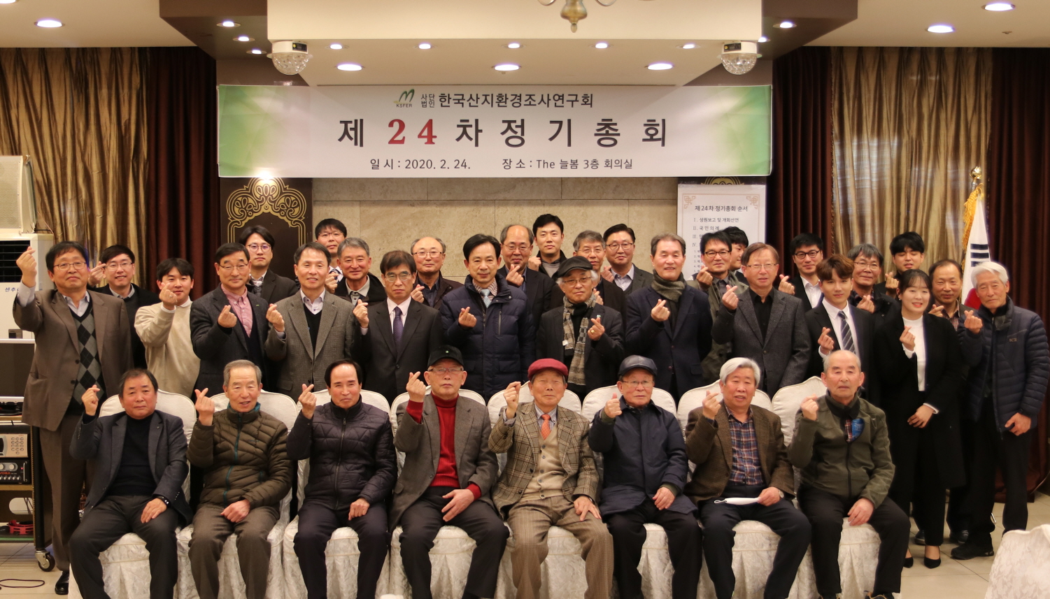 제24차 정기총회를 마친 회원들이 '제24차 정기총회' 현수막 아래에서 단체로 기념하는 모습 (2020년 2월 24일)