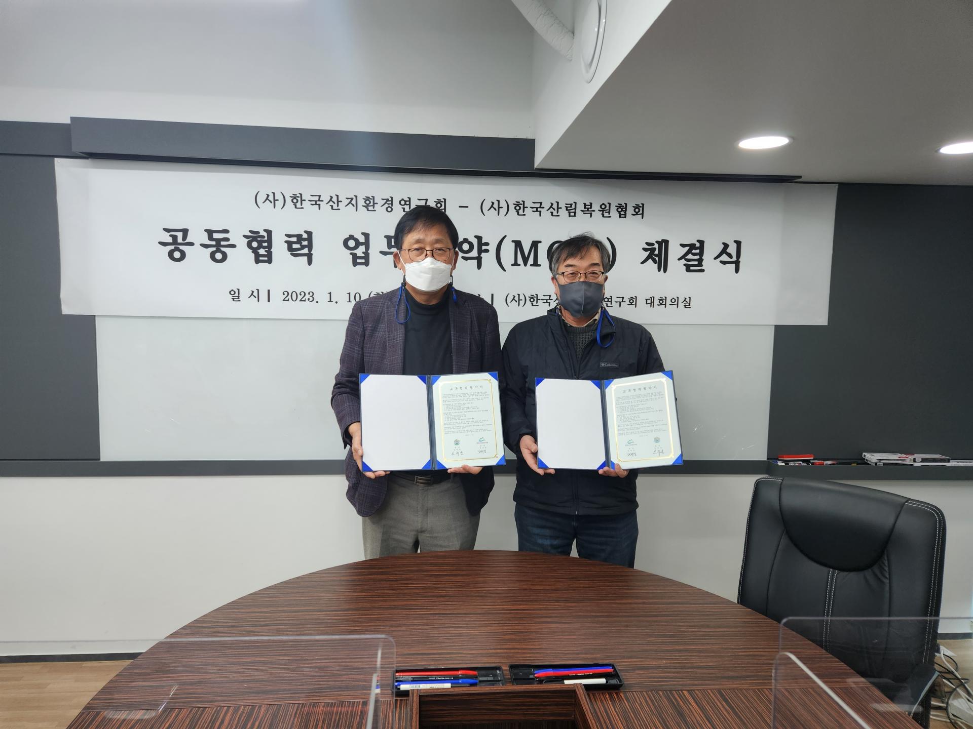 (사)한국산림복원협회 공동협력 업무협약(MOU) 체결식: 양 기관 대표가 협약서를 들고 기념하는 모습 (2023년 1월 10일)